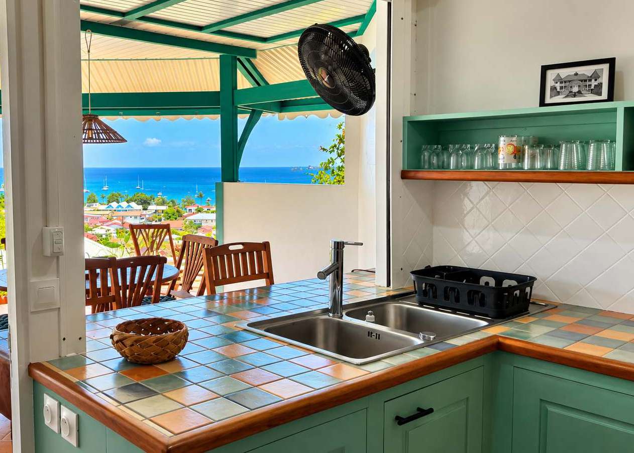 Cuisine équipée ouverte sur la terrasse avec vue mer